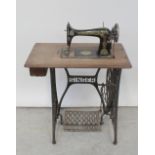 An oak-cased Singer sewing machine on wrought iron and oak treadle base, height 100cm.