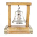 A ship's bell on beech and metal strapwork stand, from the Cunard ship Carmania,