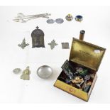 A McVitie & Price Coronation biscuit tin containing various Eastern white metal pendants, spoons,