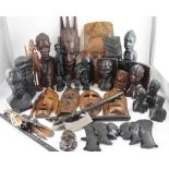 A collection of tribal art to include carved wooden masks, figural bookends, ebony African busts,