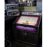 A circa 1970s jukebox with a selection of records including Elvis, The Beatles, Billy Fury, Roy