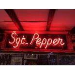 THE BEATLES; a ‘Sgt. Pepper’ red neon sign in perspex case, width approx 100cm.