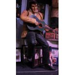 ELVIS PRESLEY; a large seated figure with guitar (left hand af), height approx 172cm, and related