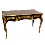 An early to mid-20th century French bureau plat, the shaped leather set top with brass mounts and