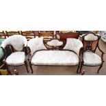 An Edwardian mahogany three piece salon suite comprising settee, elbow chair and tub chair, all with