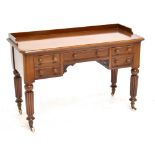 A Victorian mahogany five drawer writing table, raised on fluted column supports, width 122cm.