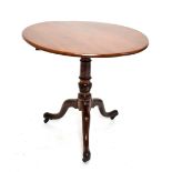 A George III mahogany tilt top tripod table on castors, diameter 79cm.