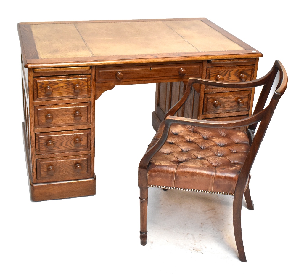 An oak twin pedestal desk with gilt tooled cream leather writing surface, 77 x 124cm and leather