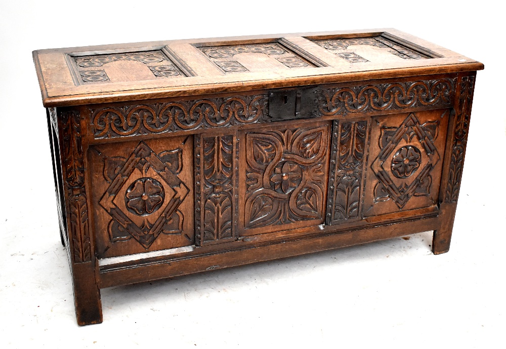 An 18th century carved oak coffer with panelled decorated, width 134cm.