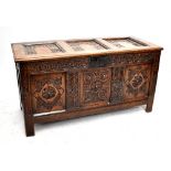 An 18th century carved oak coffer with panelled decorated, width 134cm.