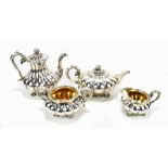 A silver plated four piece tea service having panelled decoration with cast outswept feet.