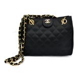 CHANEL; a black satin quilted evening bag featuring a fabric and gold chained shoulder strap and a