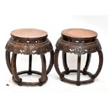 A pair of Chinese stools with carved friezes above aprons further carved with lotus sprays on curved