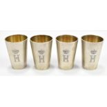 A set of four German 800 silver tot cups all initialled 'H' beneath crown, of tapered form with gilt