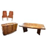 An Art Deco burr walnut veneered dining suite comprising shaped rectangular table, raised on
