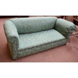 A Victorian green upholstered drop-end sofa on bun feet.