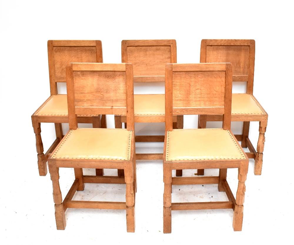 ROBERT 'MOUSEMAN' THOMPSON; a set of five light oak dining chairs, each raised on block supports.