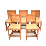 ROBERT 'MOUSEMAN' THOMPSON; a set of five light oak dining chairs, each raised on block supports.