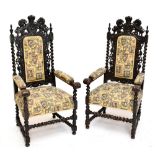A pair of early 20th century carved oak throne chairs in the Carolean style, the backs with