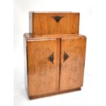 An Art Deco walnut cocktail cabinet, the hinged pull down door with mirrored interior, height 116cm