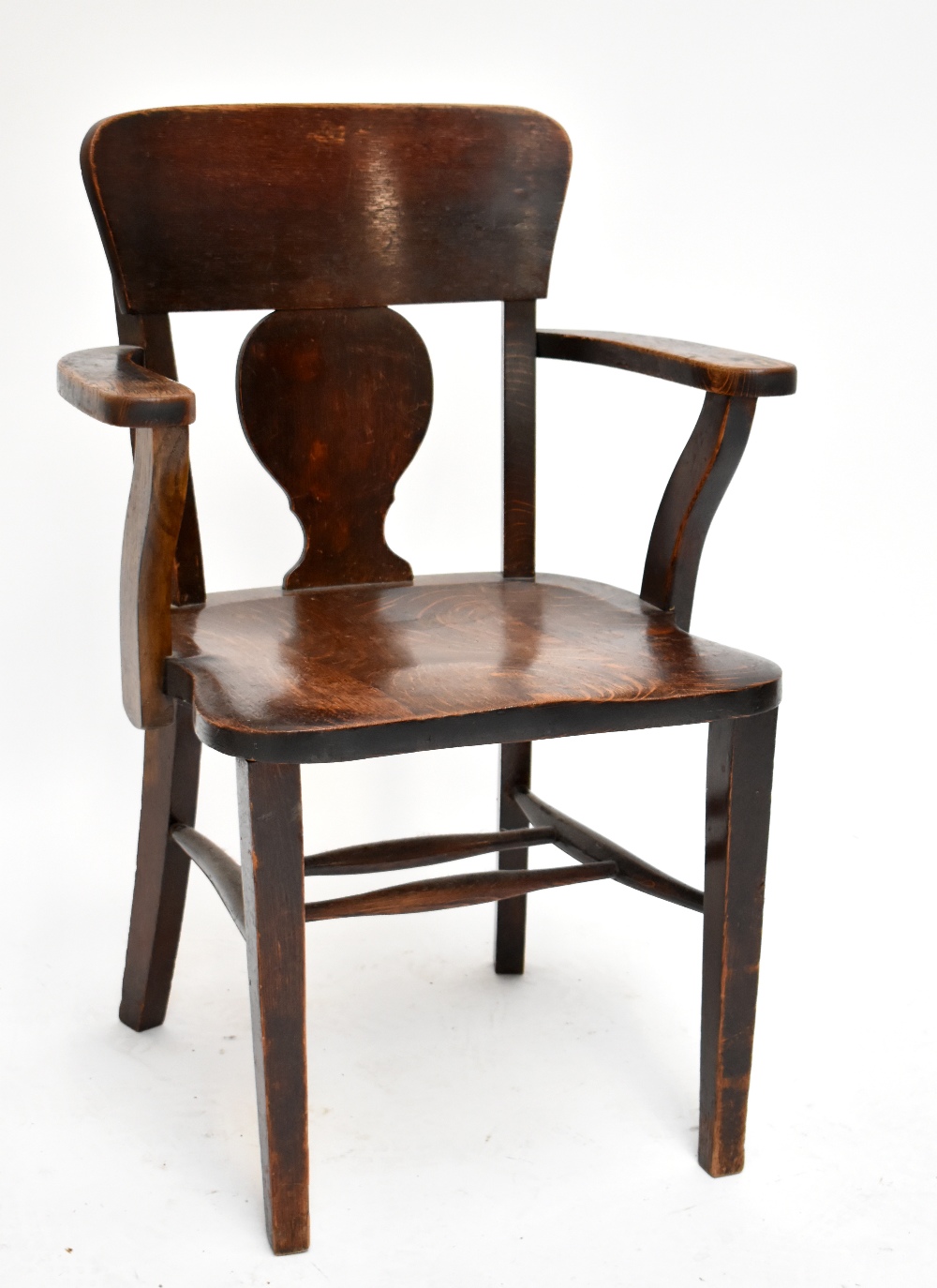 A 1920s oak armchair raised on block supports.