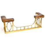 A late Victorian/Edwardian brass club fender with square sectioned uprights, padded seat and