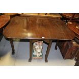 An early 20th century oak drop leaf table on reeded legs, length when extended 136cm.