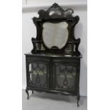 An Edwardian ebonised Empire cabinet, shaped mirror and shelves above two door glazed base,