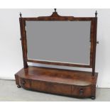 An early 19th century mahogany swing mirror, decorative urn finials to the top,