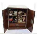 A late Victorian double-fronted tabletop cabinet opening to reveal vintage medical supplies,