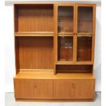 A G-Plan lounge unit with an open shelf bookcase and a glazed cabinet surmounting a four-cupboard