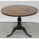 A George III oak circular tilt-top table on tripartite support and a 19th century walnut dining