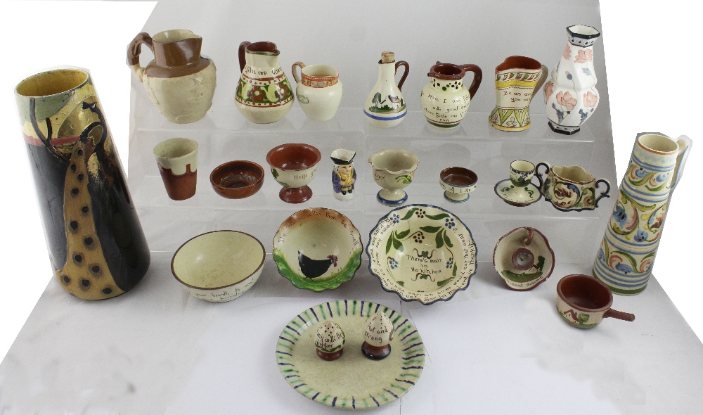 A collection of Torquay motto ware pottery, other examples including a peacock vase,