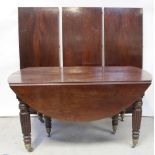 An early 19th century mahogany oval extending dining table, to reeded baluster supports and castors,