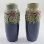 Royal Doulton; a pair of baluster vases with blue drip glaze ground and applied floral decoration,