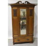 A late Victorian golden oak single wardrobe with mirrored door and lower drawer on bracket feet,