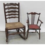 A late 19th/early 20th century oak ladder-back rocking chair with rush seat and turned