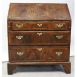 A George III oak carcass bureau with walnut frontage, drop-down desk top with interior pigeonholes,