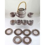 A lilac-covered studio pottery tea set of six cups, six saucers and teapot with bamboo handle,