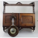 A late Victorian red walnut wall-mounted shelf rack and cabinet, width 59.