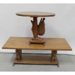 An elliptical table with carved tree-climbing crocodile support and a rectangular table supported