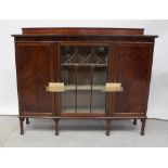 A 1930s mahogany bookcase cabinet with glazed central door flanked by two wood panel doors on