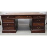 A 20th century reproduction mahogany partners desk with brown tooled leather, drawers to one side,