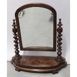 A Victorian mahogany swing mirror, wrythen supports to either side to a curving base.