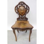 A 19th century Tyrolean hall chair with bas relief carved naturalistic back splat with marquetry