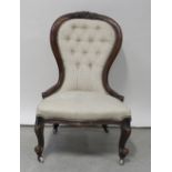 A Victorian walnut spoon-back fireside chair in deep buttoned patterned cream fabric, height 91cm..