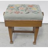 An Edwardian piano stool, tapering supports and cross-stretcher with floral tapestry seat.