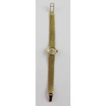 Omega; an 18ct gold ladies wristwatch the dial set with baton numerals, on textured gold strap,