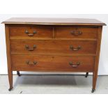 An Edwardian mahogany inlaid two-over-two chest of drawers to tapering supports and castors,