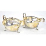 VINER'S LTD; a pair Elizabeth II hallmarked silver sauce boats, each raised on three hoof feet,